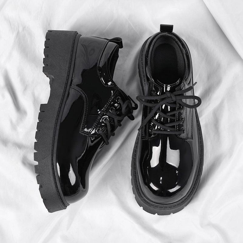 Black leather lace-up shoes with glossy finish, lace eyelets, and rugged lug sole