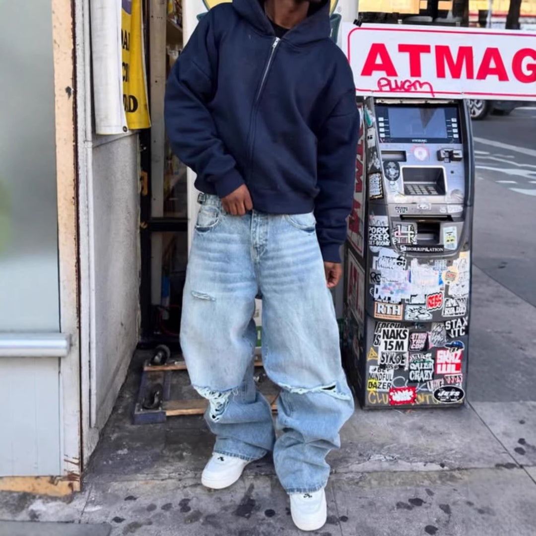 Light-wash ripped men’s jeans with distressed knees and relaxed straight-leg fit