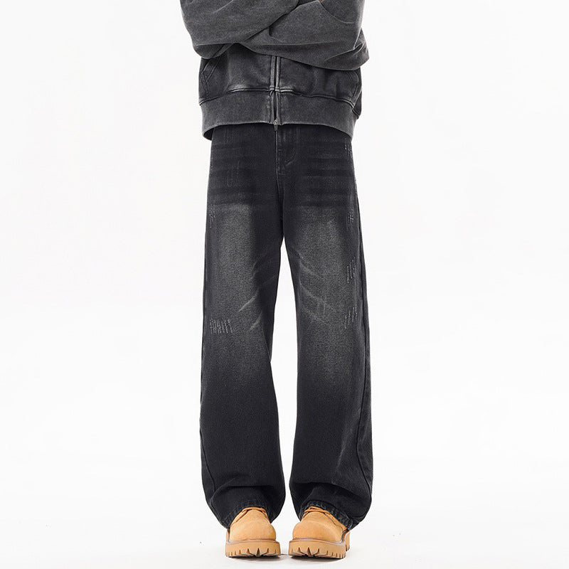 Men's dark distressed jeans with wide legs and subtle fade wash at knees