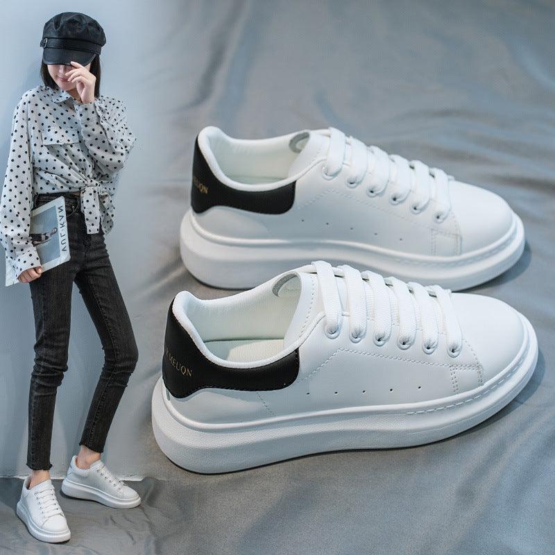 Women's white platform sneakers with black side stripe and lace-up front