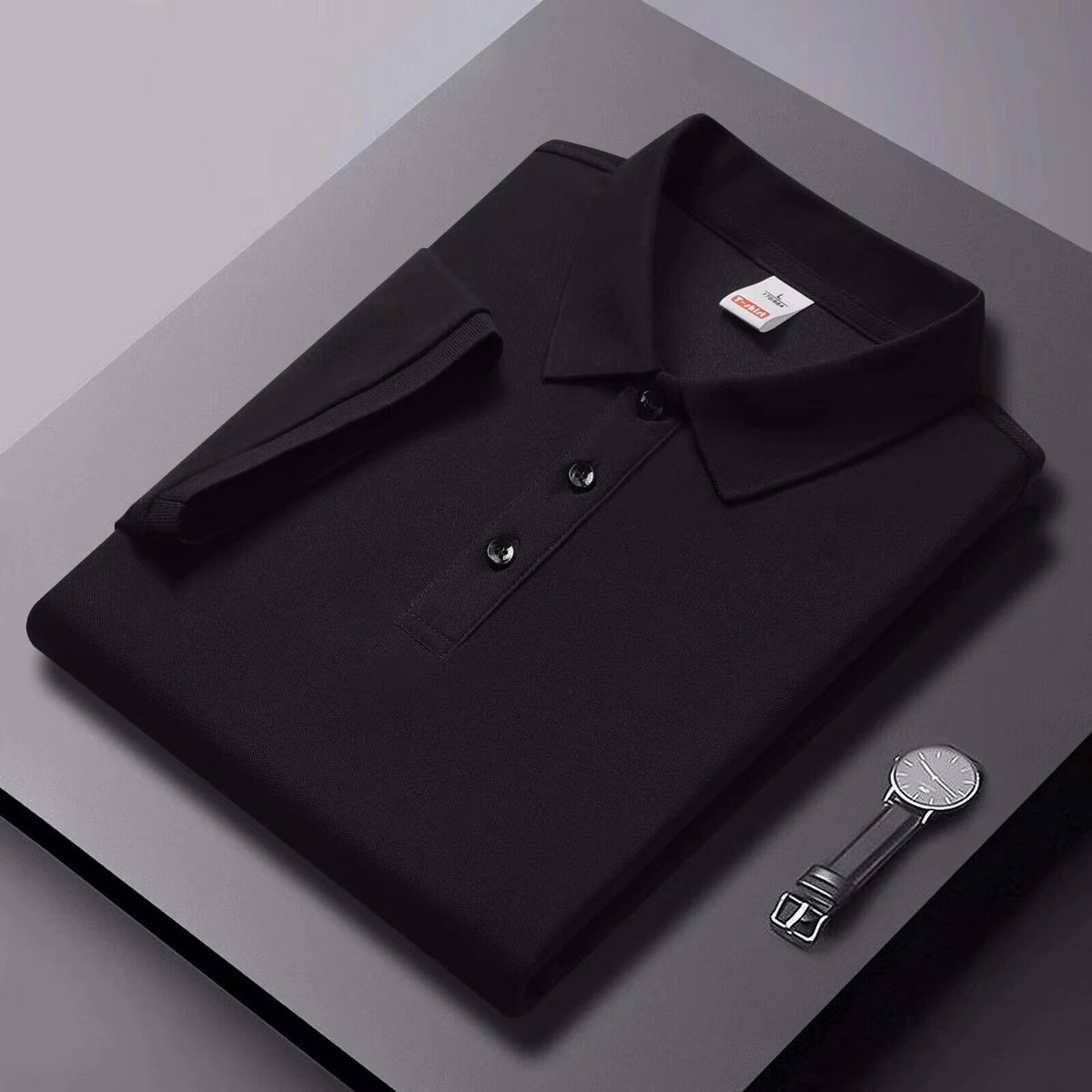 Black short-sleeve polo shirt with collar and button placket, flat lay.