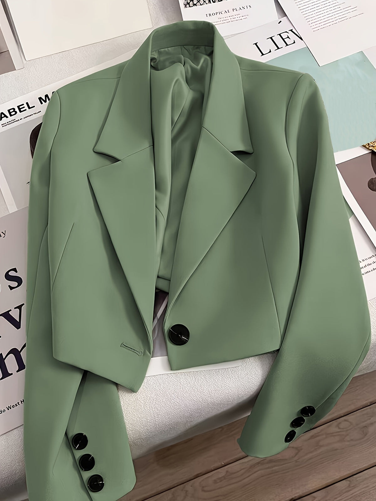 Green tailored blazer with notched lapels and button cuffs