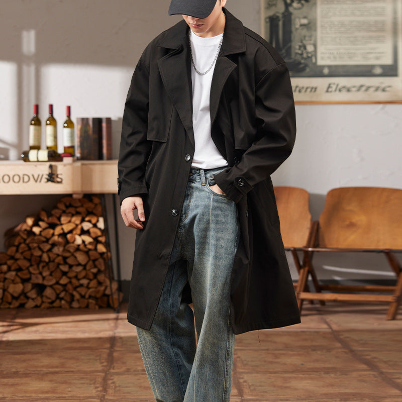 Men's black mid-length trench coat with wide lapels and button-front closure, flap pockets.