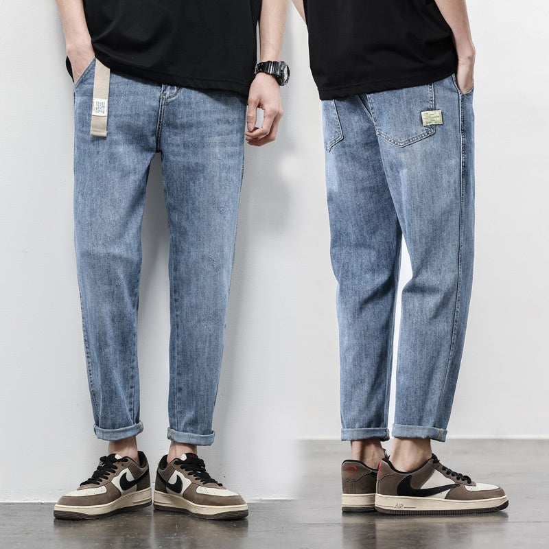 Light blue thin denim jeans, loose straight-leg fit, cuffed hem, tan patch pocket