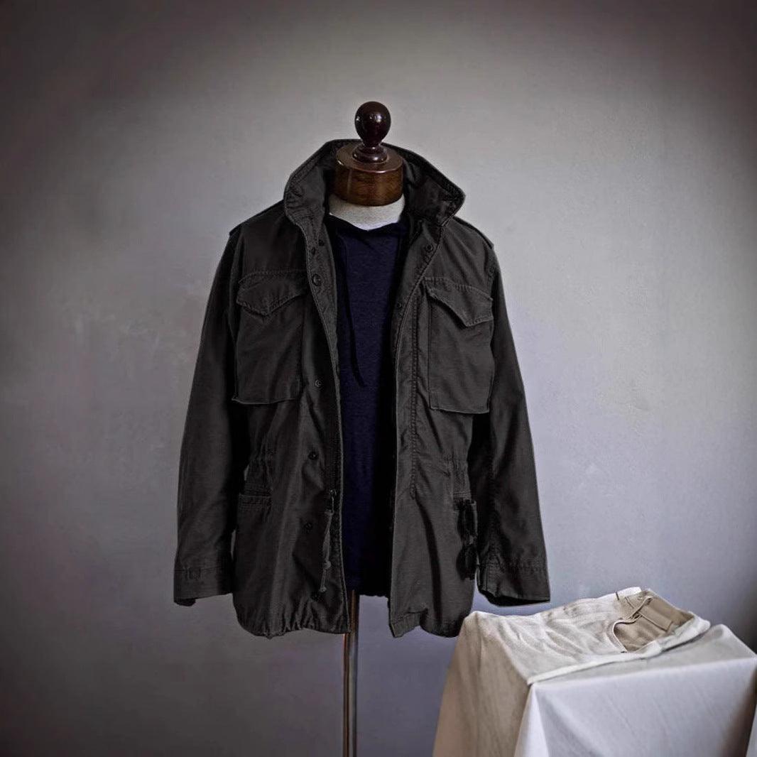 Men's vintage work jacket on mannequin, dark color with flap pockets and button front