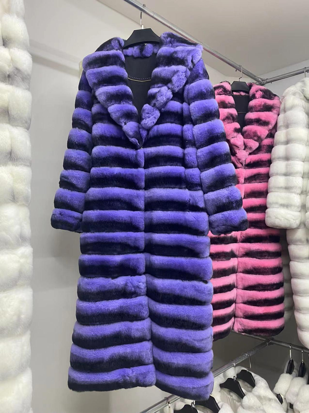 Purple and pink striped fur long coats on hangers with standing collar