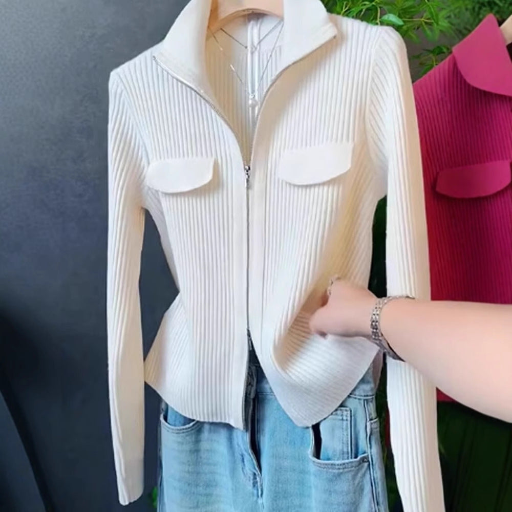 White zip-front sweater with ribbed texture, stand collar, and two chest patch pockets