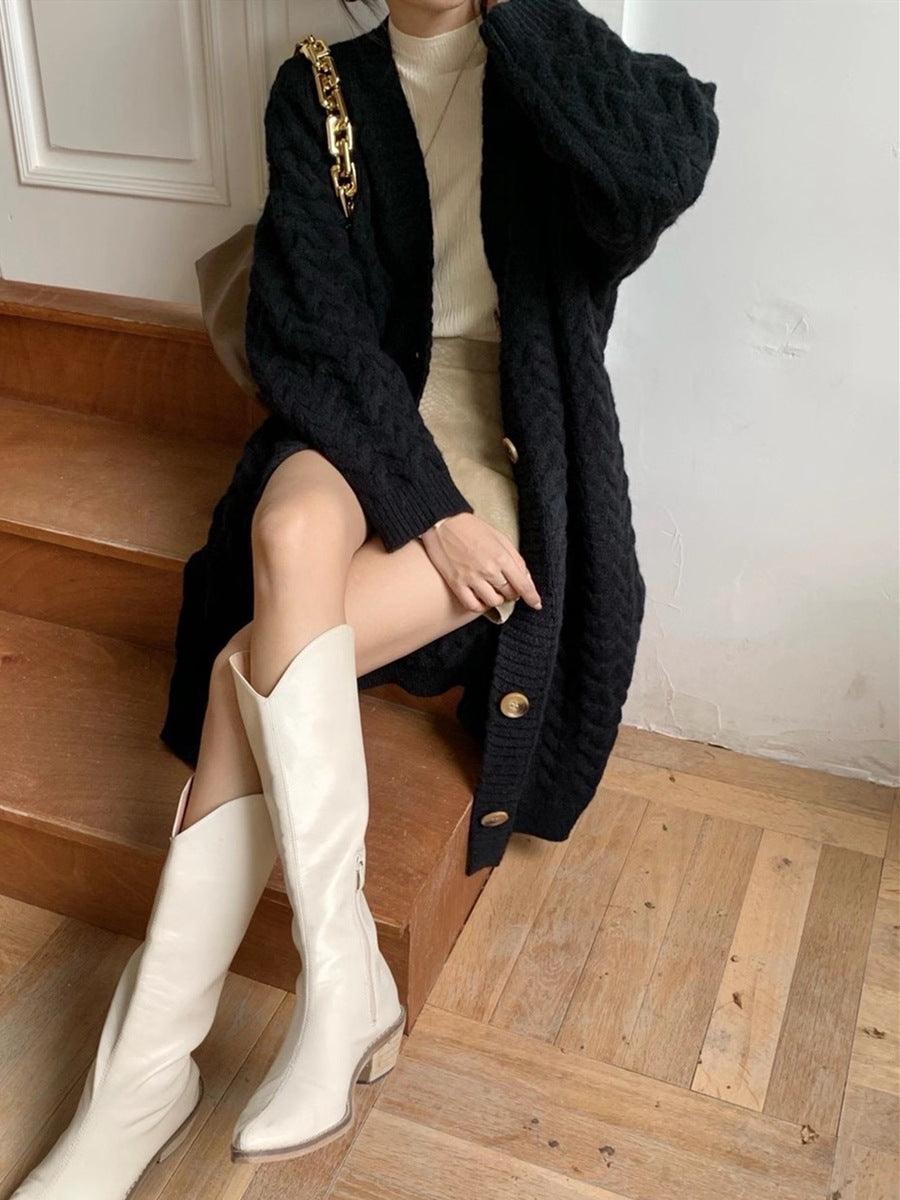 Long thick knitted cardigan in black with textured cable knit, V-neck, and button placket