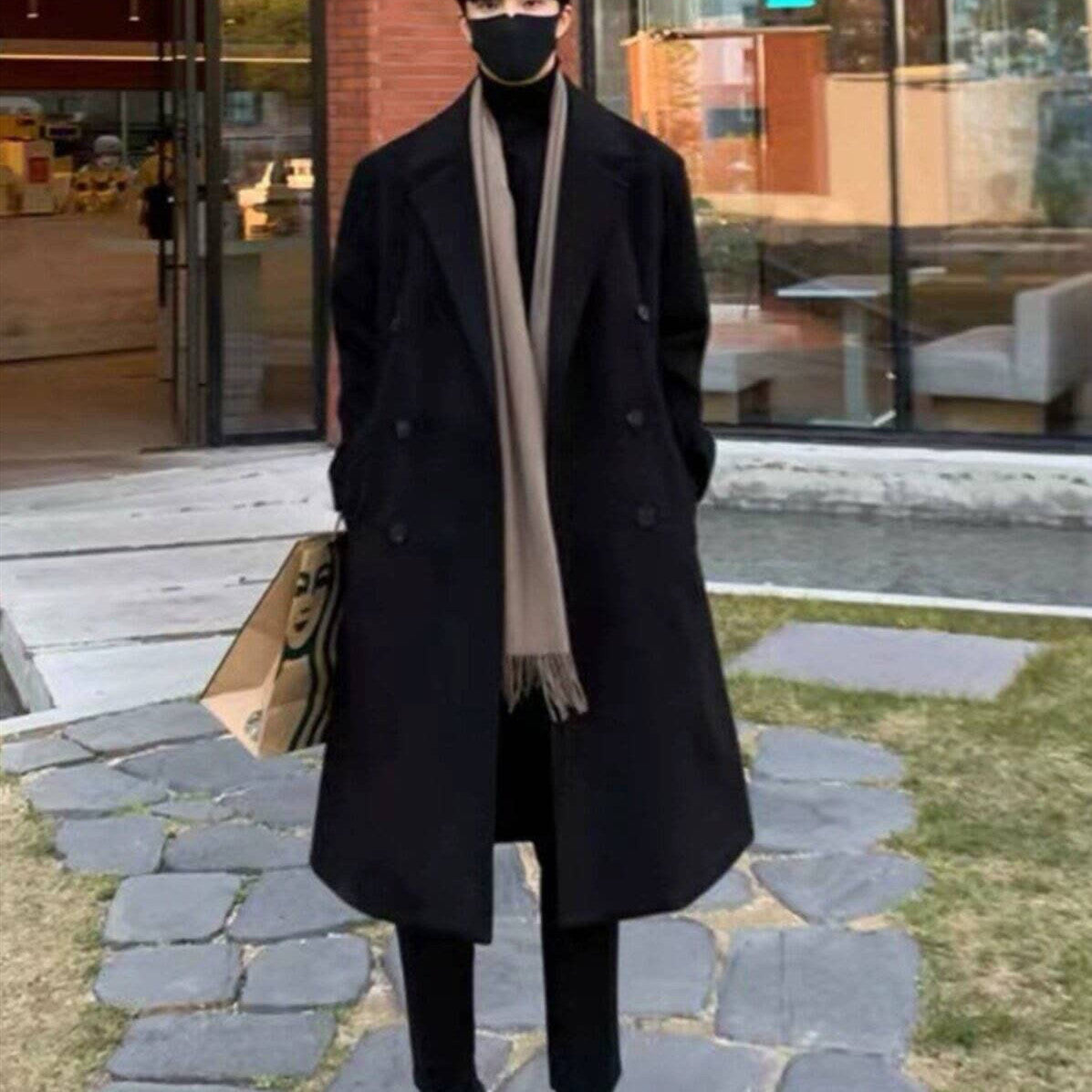 Black double-breasted wool trench coat with wide lapels and long length.