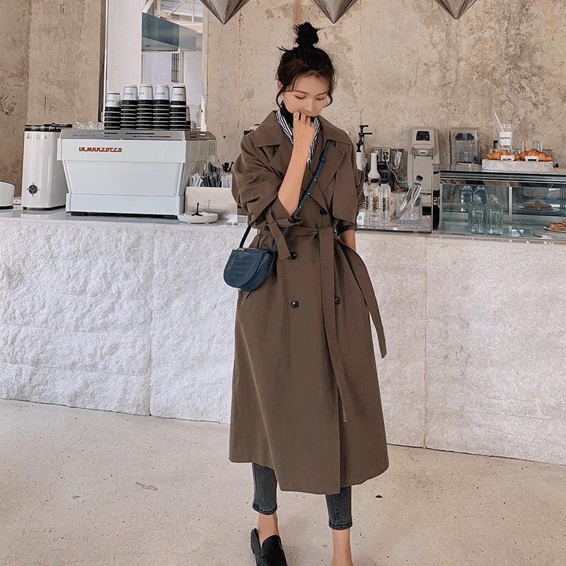 Coffee long trench coat with double-breasted front, suit lapels, and waist belt