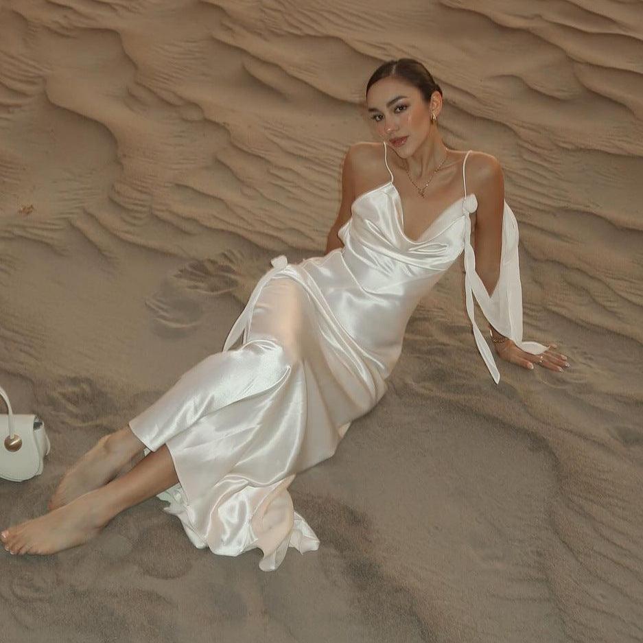 White satin backless maxi dress with spaghetti straps and bow-tied detailing