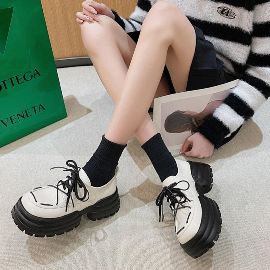 Cream lace-up sneakers with black chunky tread soles