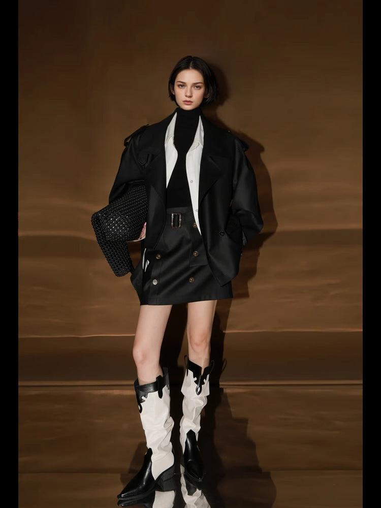 Black oversized trench coat with wide lapels, button closure, and flap pockets