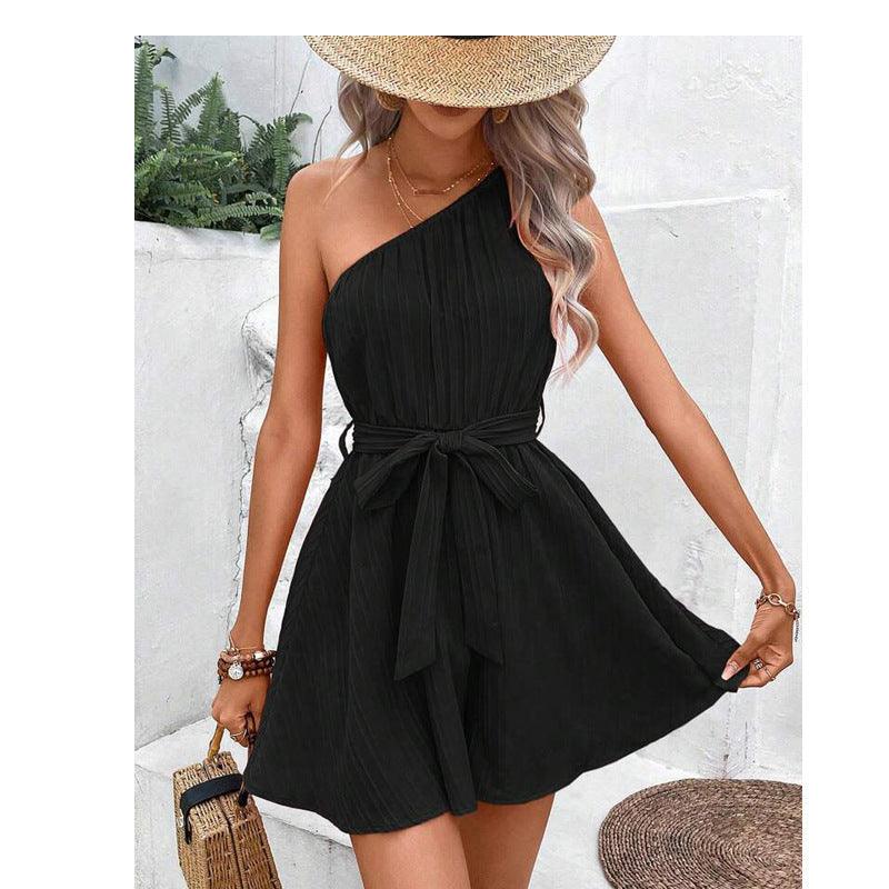 Black sleeveless one-shoulder jumpsuit with waist tie and pleated flared shorts