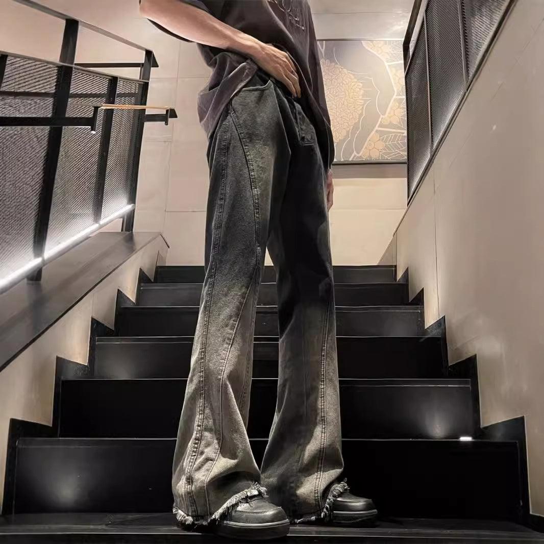Black and gray gradient washed jeans with wide flare legs and frayed hem