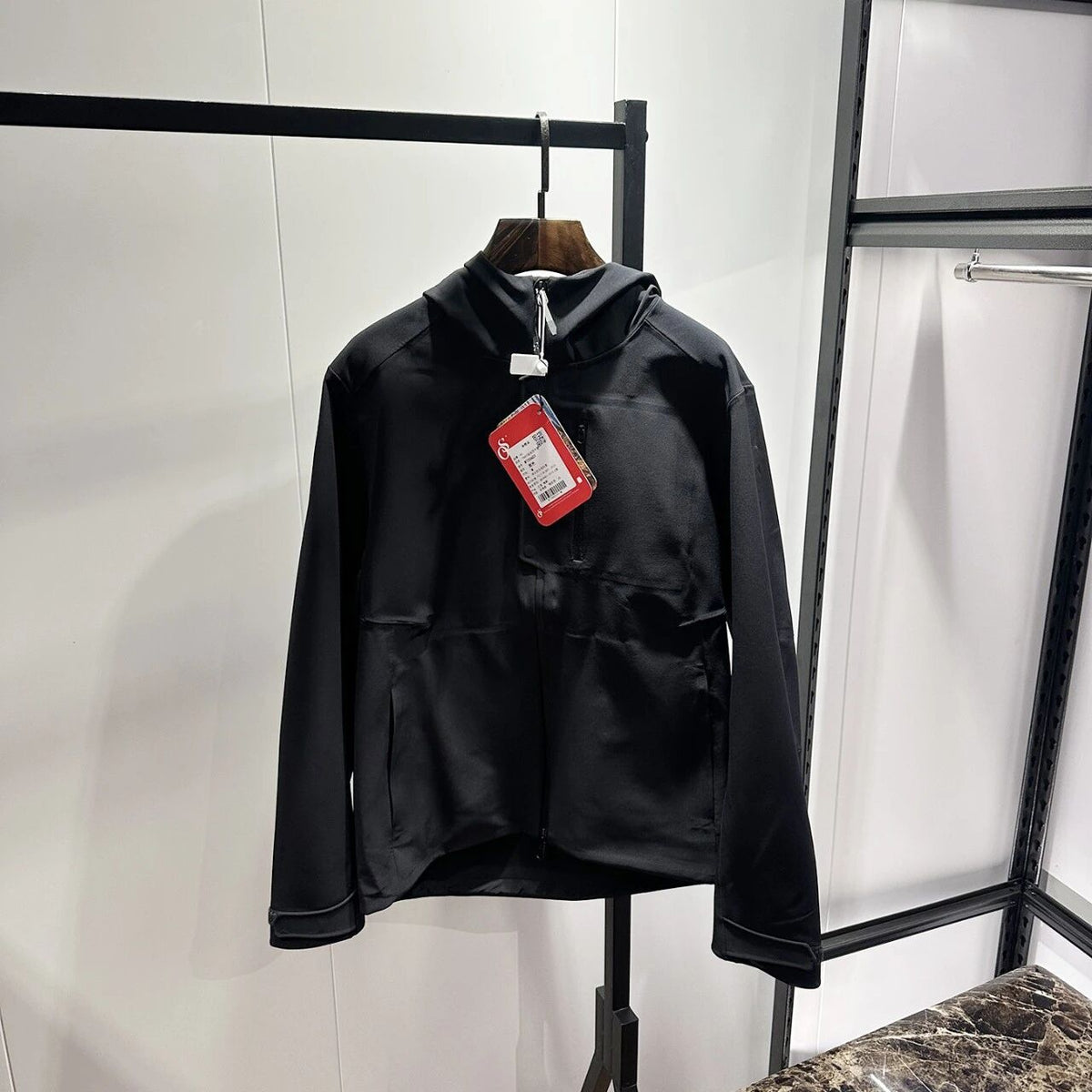 Black hooded zip-up softshell jacket with taped seams and front zipper closure.