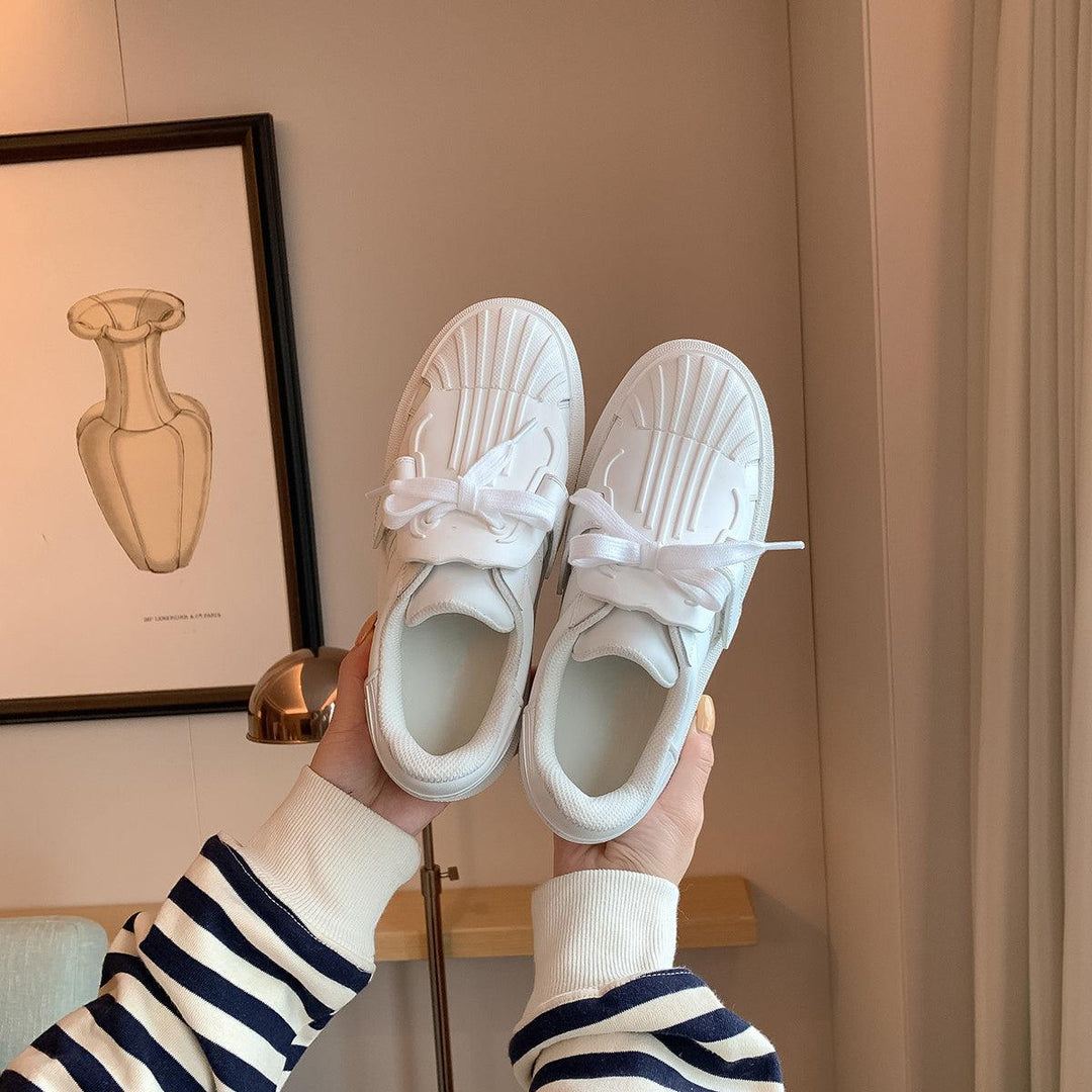 Women’s white shell-toe platform sneakers with lace-up bows