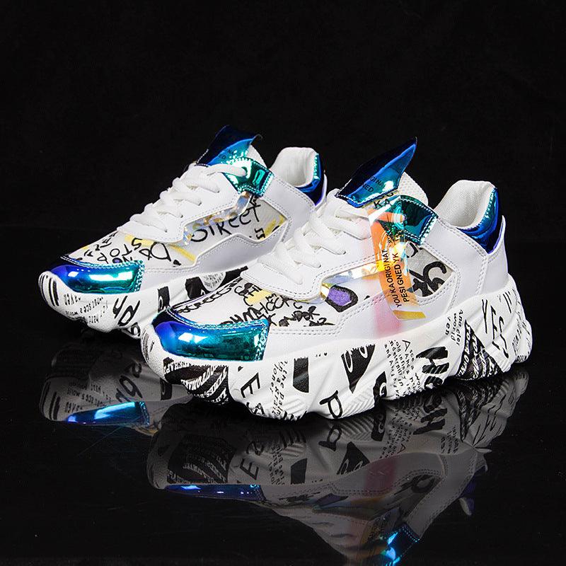 White chunky sneakers with graffiti prints and blue metallic-looking heel and toe accents