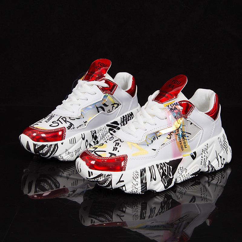 White chunky sneakers with graffiti-style prints and red heel accents, lace-up pair