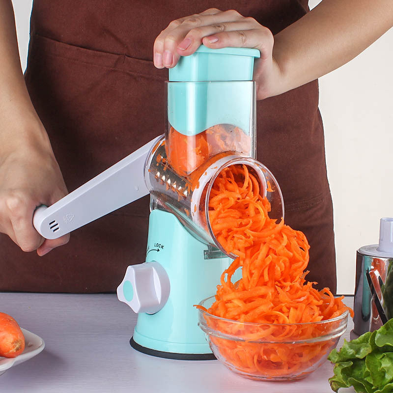 Blue vegetable chopper being operated, shredding carrots into a bowl