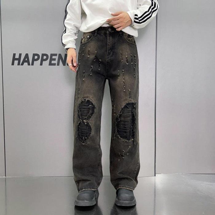 Black wide-leg jeans with heavy ripped knee patches and scattered dark stitch marks