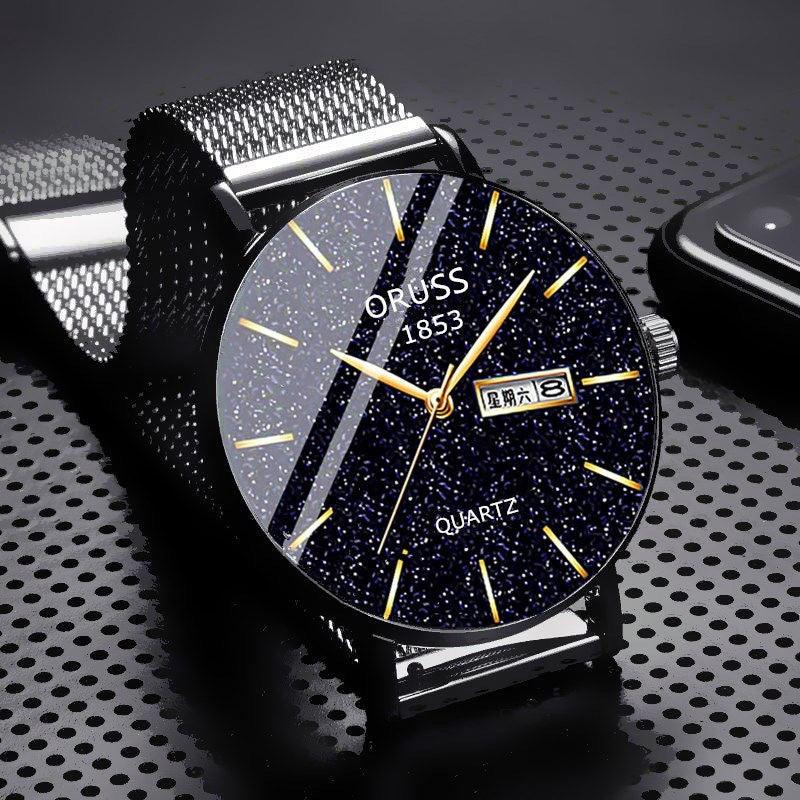 Black mesh strap mechanical-style wristwatch with navy starry dial and gold hour markers