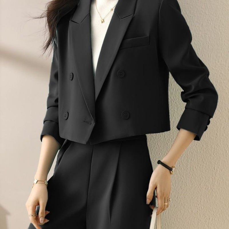 Black short blazer with notched lapels, double-button front, and chest welt pocket.