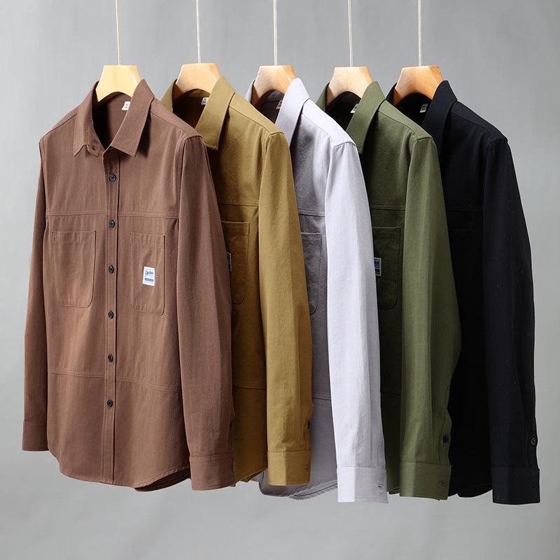 Brown button-up youth shirt jacket with chest pockets and long sleeves, on hangers