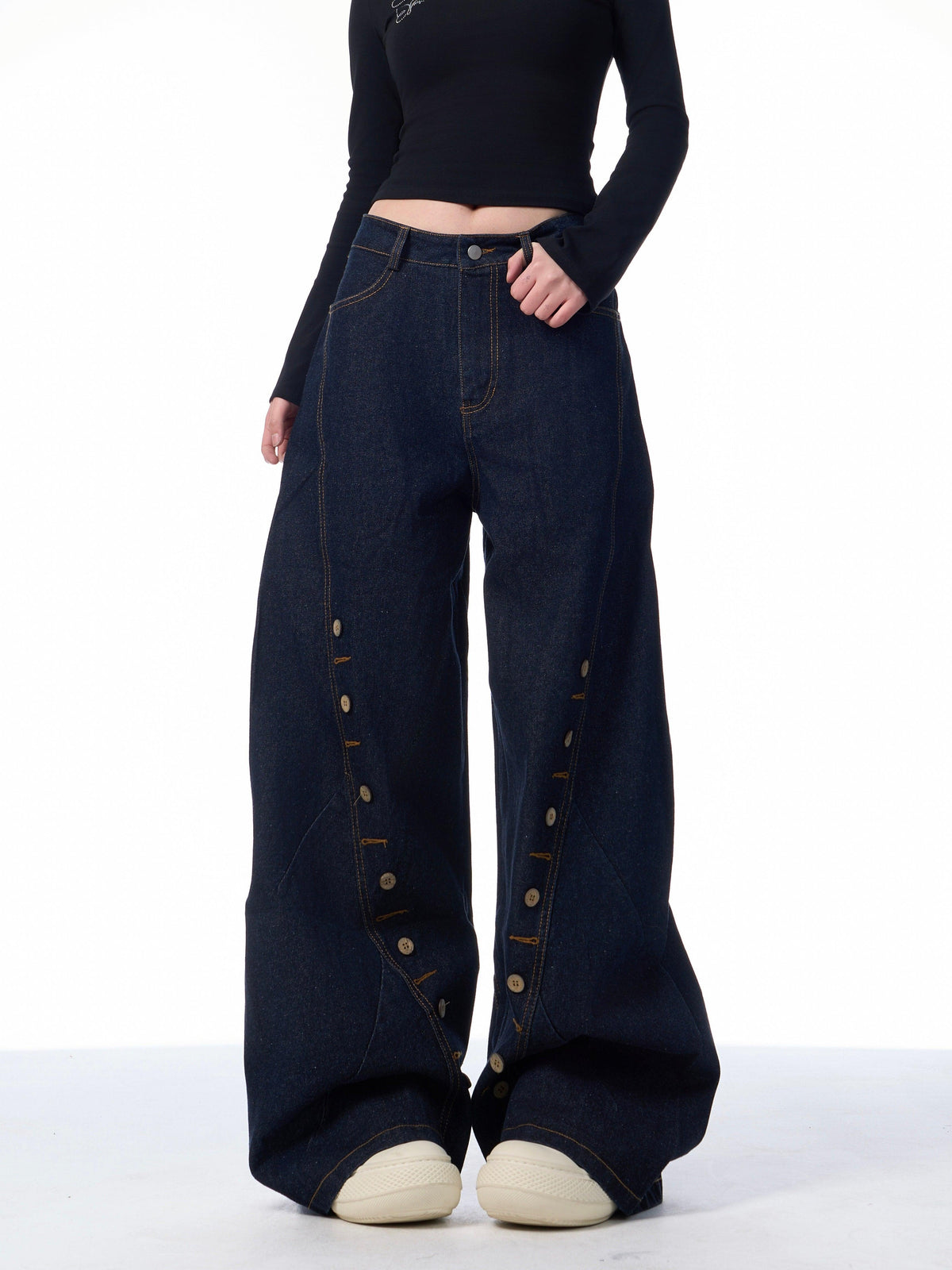 Black wide-leg denim pants featuring multi-row buttonhole eyelets along the front