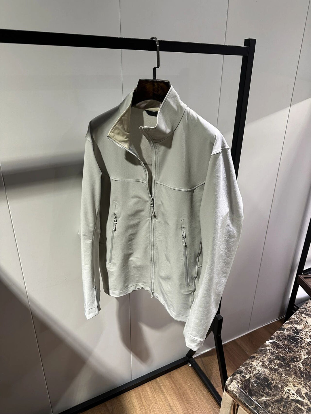 Light gray zip-up outdoor jacket with stand collar and front zipper