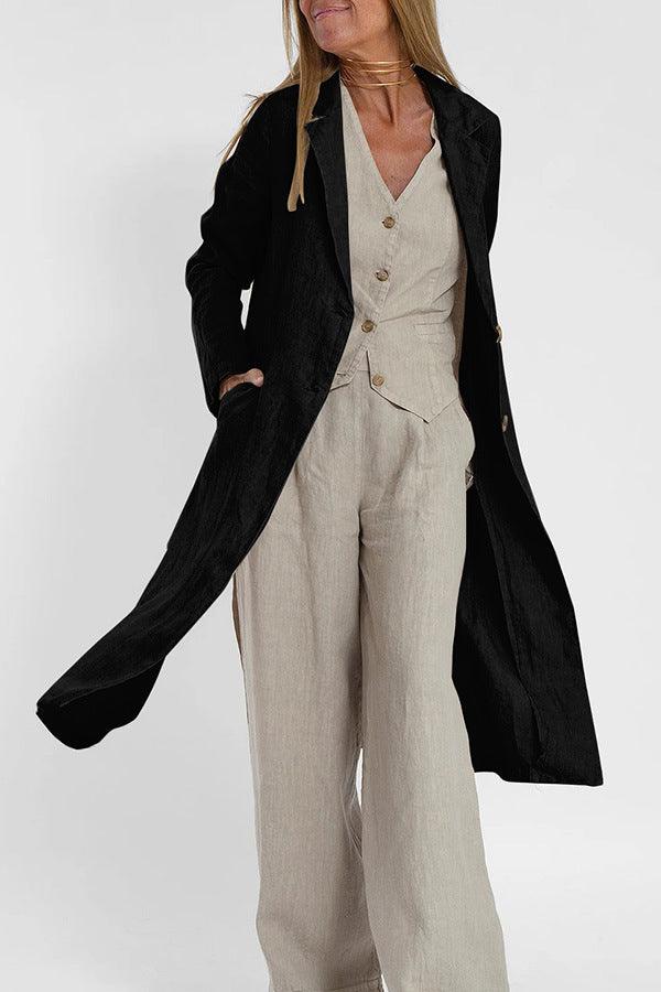 Black long trench coat with notch collar and button front over beige clothing