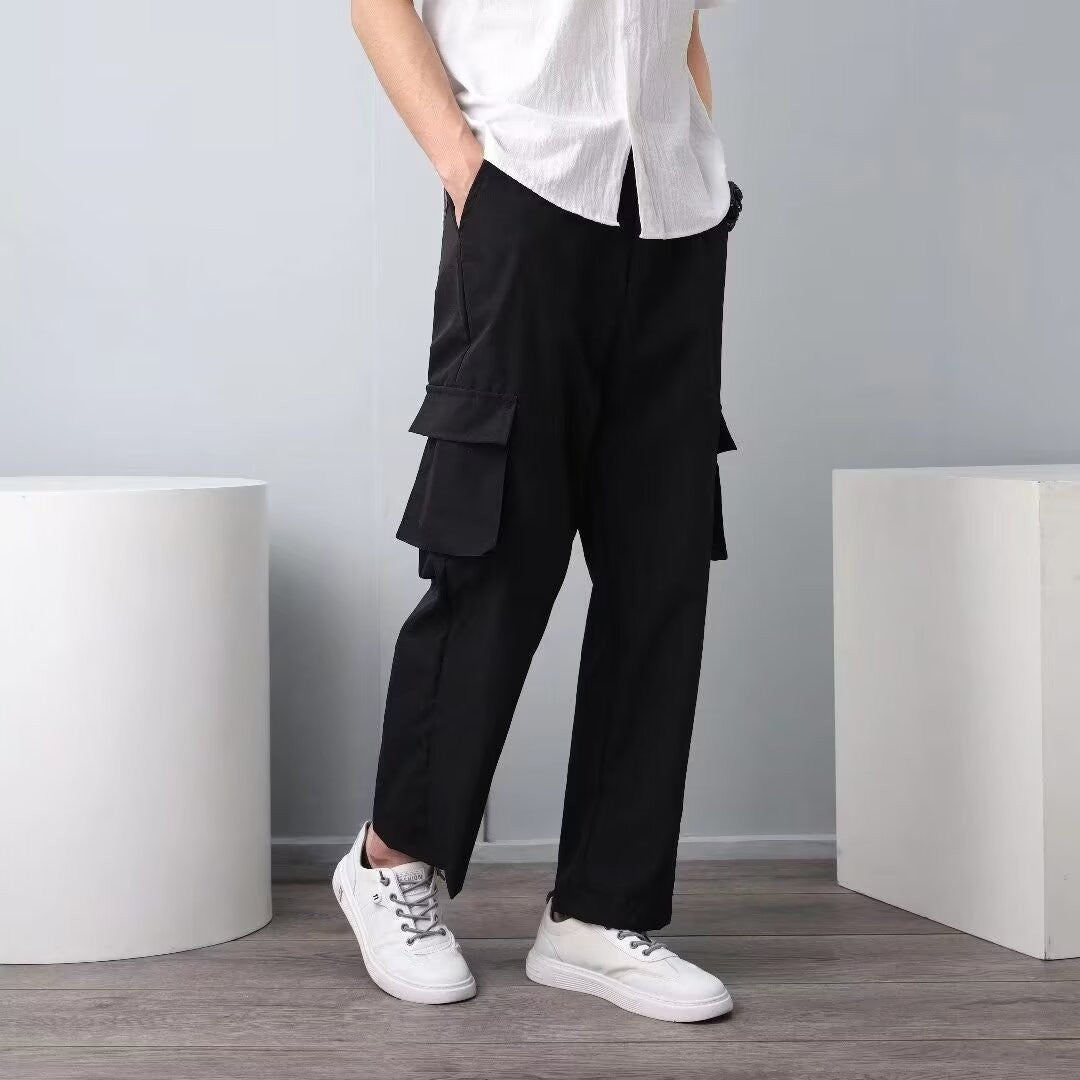 Men's black cargo pants with layered side flap pockets and wide straight legs