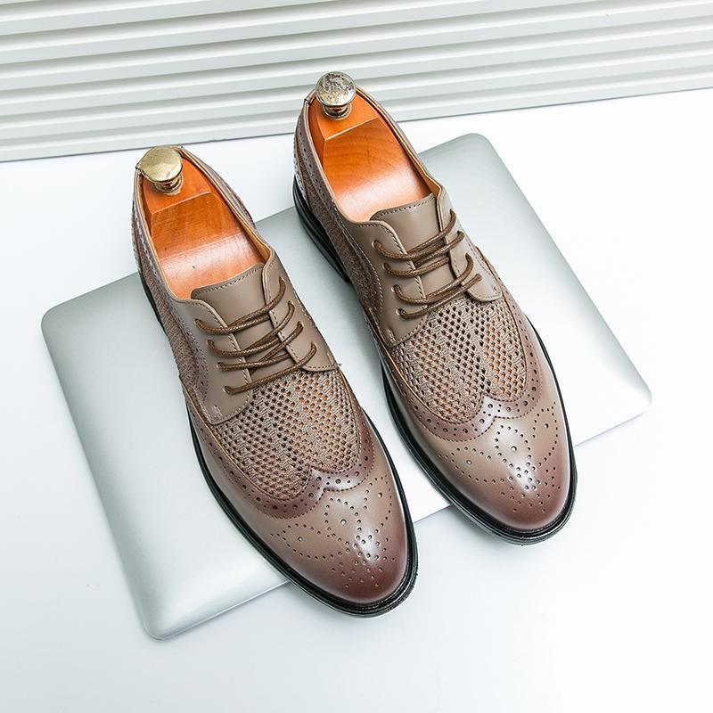 Tan leather lace-up business shoes with perforated design and brogue toe, on tray