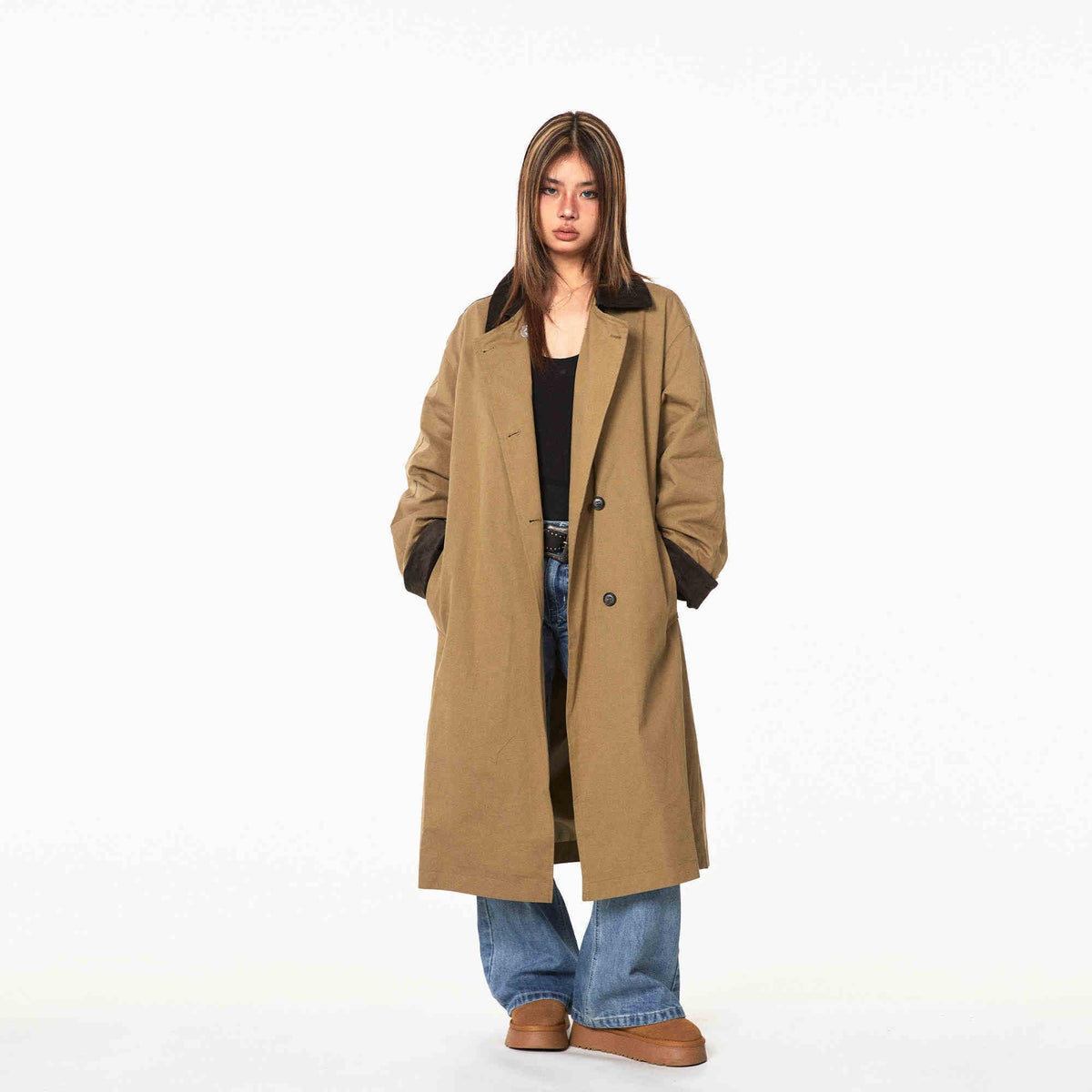 Tan trench coat, mid-calf length, lapel with dark patchwork; double-breasted buttons