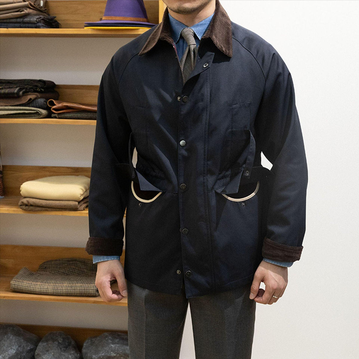 Men's dark blue waterproof trench coat with brown collar and flap pockets, button front