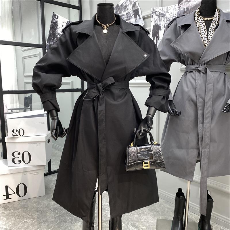 Black over-the-knee belted trench coat with notched lapels and front tie belt