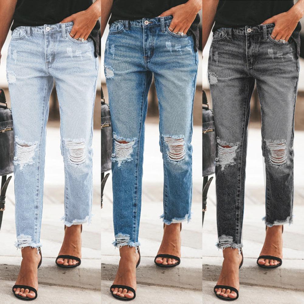Women's light blue ripped cropped jeans with frayed knees and distressed patches