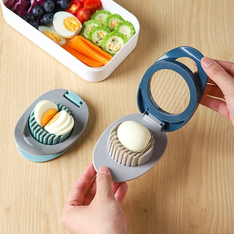 Blue-and-grey egg slicing gadget with wire grid, held by hand over base