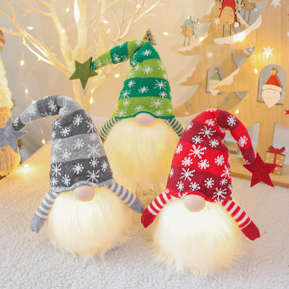 Christmas gnome doll with green knitted hat and white fluffy beard, striped arms.