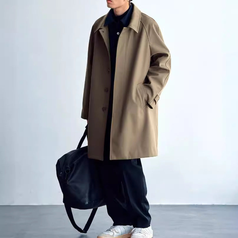 Dark wool trench coat with raglan sleeves, button front, and wide collar.
