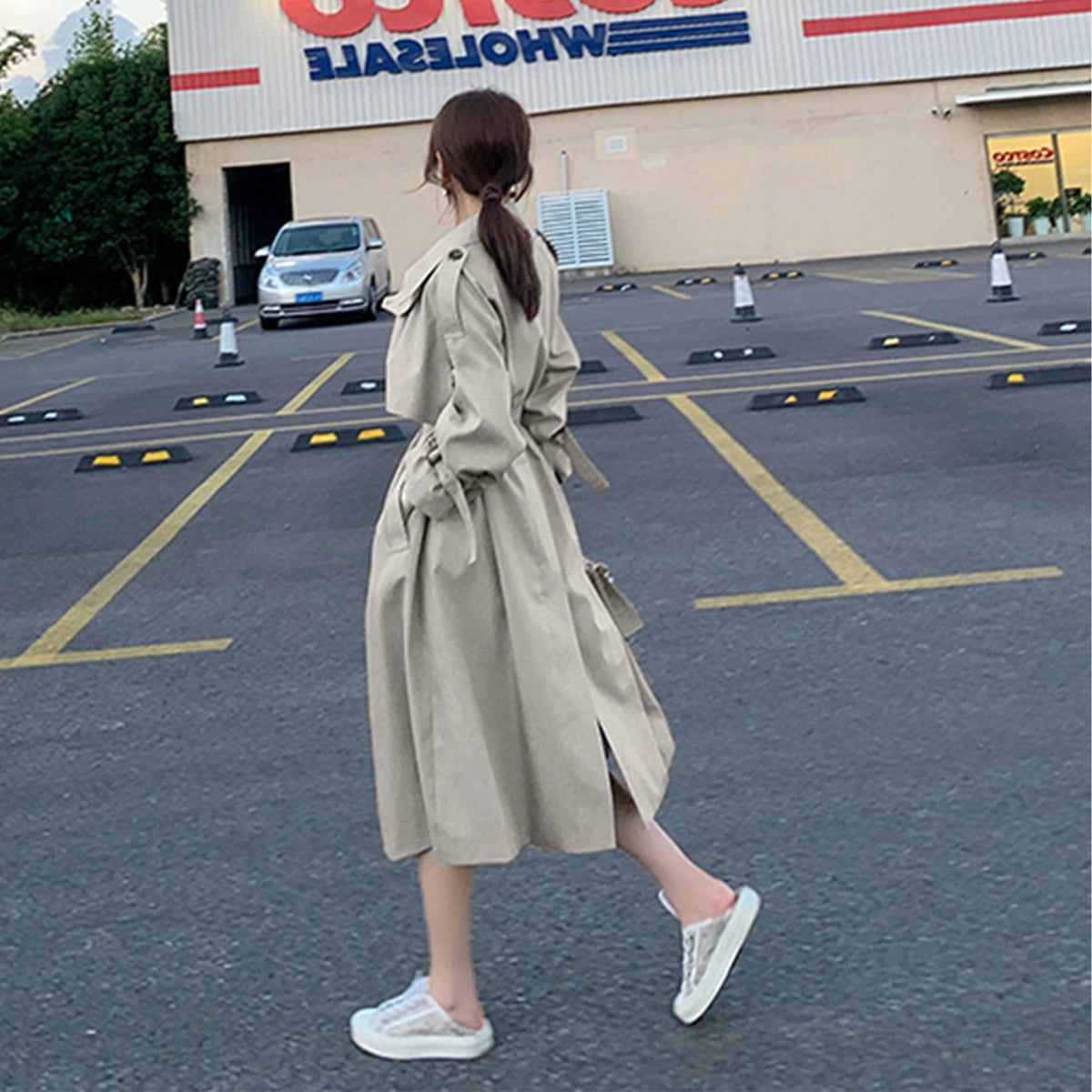 Women’s light beige trench coat with belted waist and long, loose sleeves