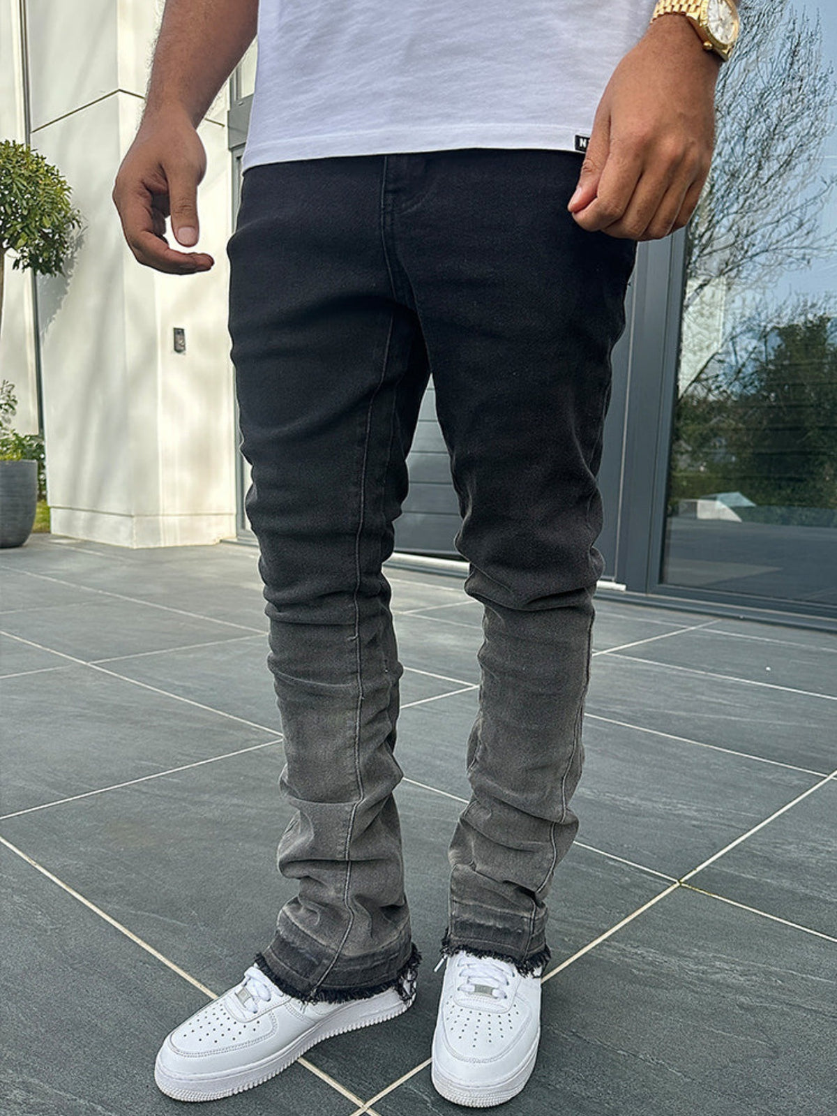 Mens gradient-washed jeans, dark front with lightened knee fades and ripped ankle cuffs.