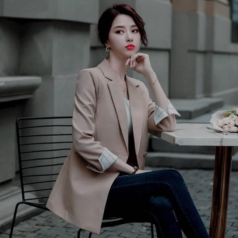 Women’s tan blazer with notched lapels, button front, and cuffed sleeves over light top