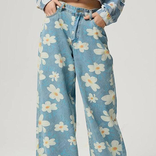 Blue straight jeans with large white and yellow daisy floral print, belt loops and zipper