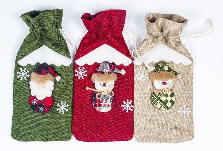 Three Christmas wine bottle socks: green, red, and beige with cartoon character face designs