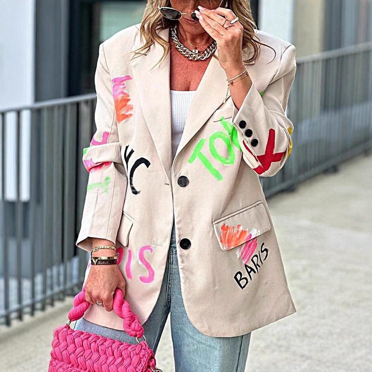 Beige blazer with colorful graffiti lettering patches and padded shoulders