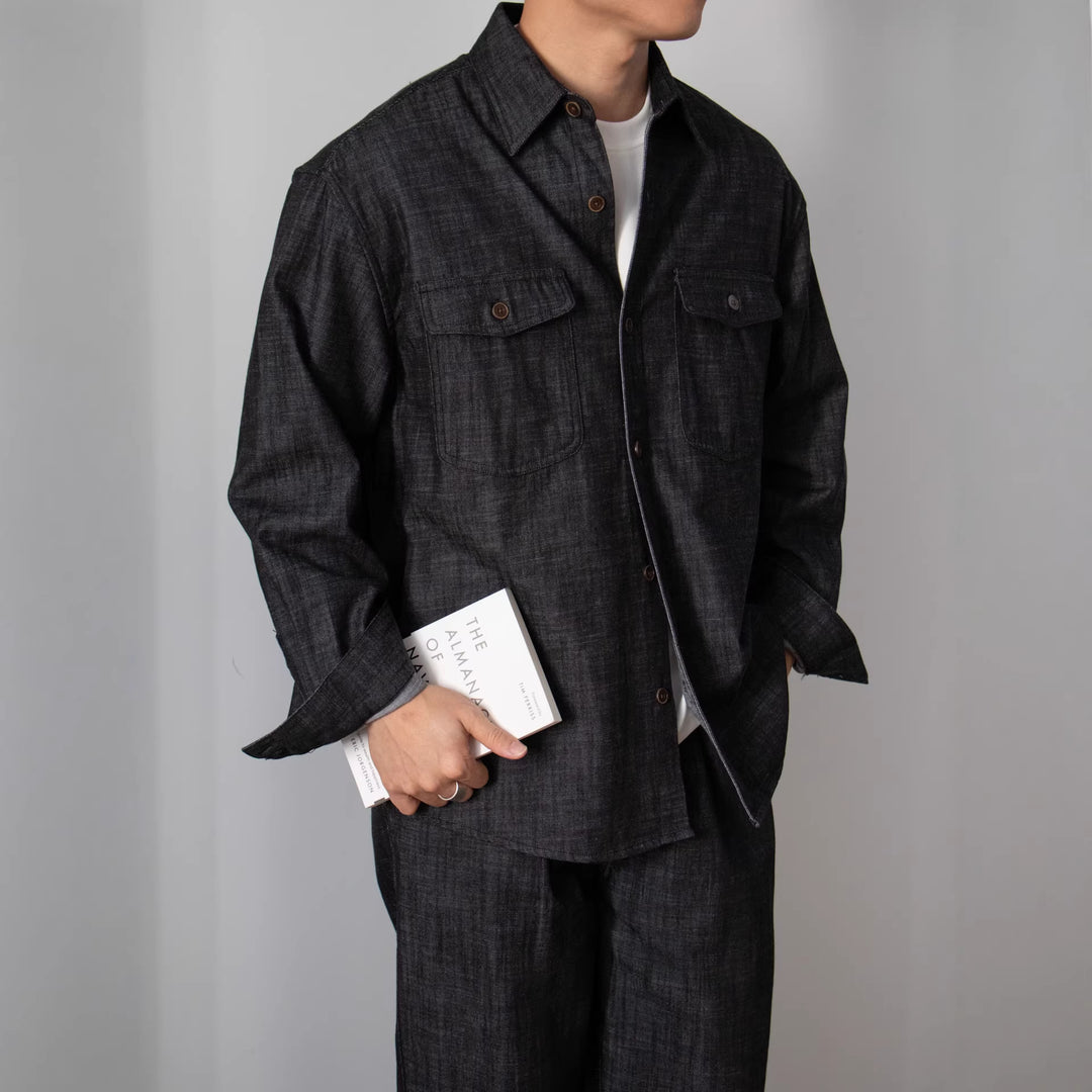 Dark charcoal long-sleeve button-up shirt with two chest flap pockets, loose fit.
