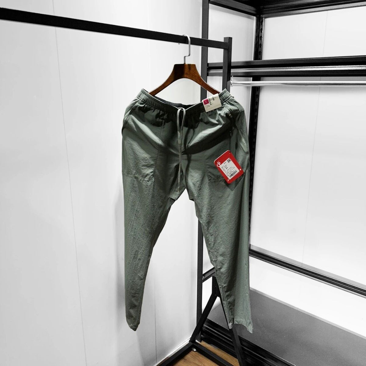 Men’s olive green softshell pants on hanger, elastic waist and drawstring