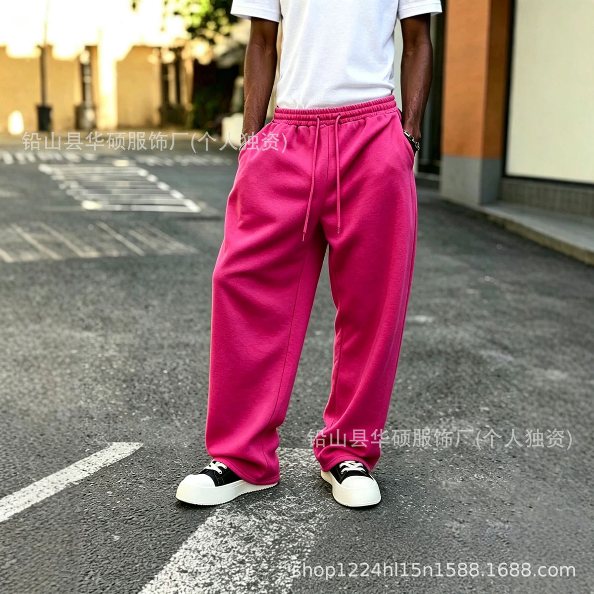 Pink elastic-waist sweatpants with drawstring, loose straight legs with ankle cuffs.