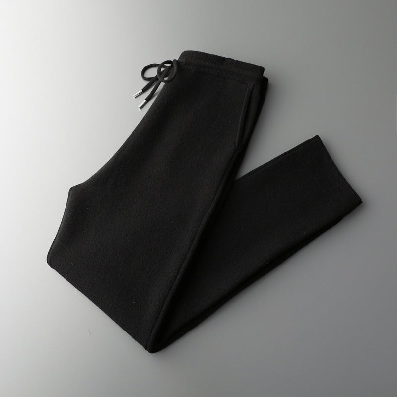 Black wool trousers folded with high waist and drawstring tie detail